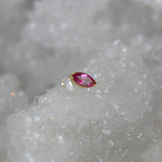 Pink gemstone in a gold setting on a textured gray background

genuine tourmaline in a marquise cut in threadless push fit attachment in 18k yellow gold from anatometal