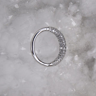 white Gold ring with embedded stones on a textured white background junipurr jewellery opulence pave ring hinge clicker with 100 cz cubic zirconia